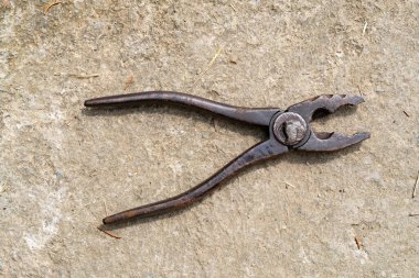 Sert beton yüzeye yerleştirilmiş tırtıklı çeneli eski paslı pense