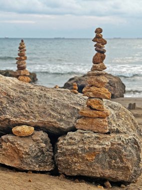 Sahildeki güzel gün batımı ışığında büyük bir kaya yığını mükemmel bir şekilde dengelenmiştir..