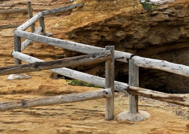 İspanya sahilindeki sahile ulaşmak için tahta korkuluklar ya da güvenlik için sahil kayalarının üzerindeki çitler.