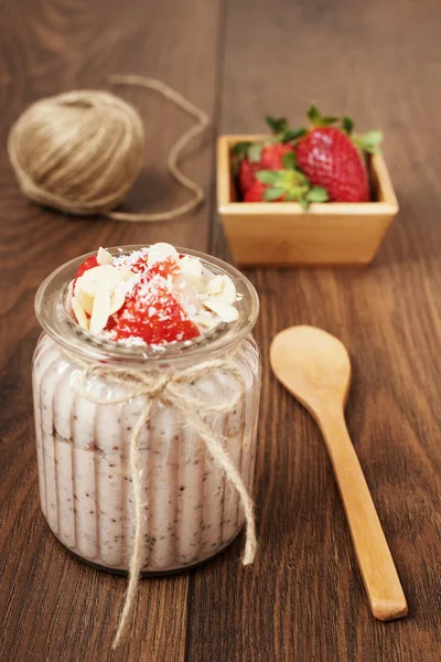 Budín de semillas de chía con fresas, plátano, almendras y coco. Fondo de madera oscura — Foto de Stock