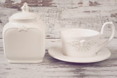 Basit rustik beyaz ve mavi çanak çömlek, boş yemekleri. Büyük kase, bardak ve porselen kapaklı kavanoz. Ahşap arka plan, shabby chic, vintage renklendirme