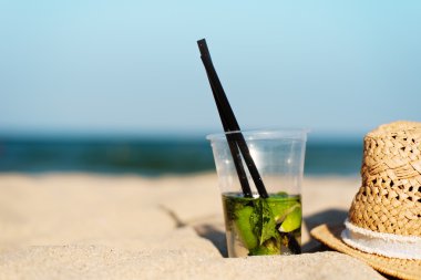 Mojito plaj ve saman şapkasını kokteyl. Kopya alanı ile plaj arka plan bulanık. Güneş, güneş sis, kamaşma