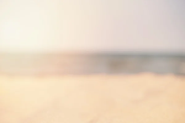 Blur playa de arena blanca de verano con agua de mar. Resumen bokeh borrosa sobre fondo colorido. Espacio para el texto. Sol, sol neblina, resplandor — Foto de Stock