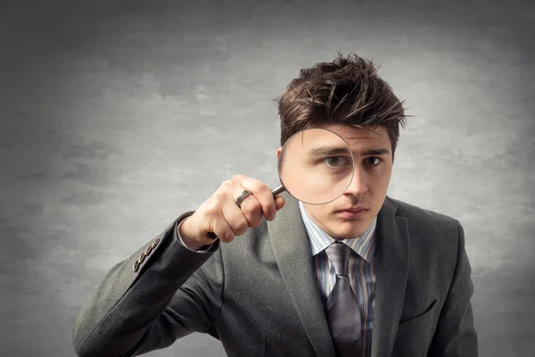 Young man with a magnifying glass — Stock Photo, Image