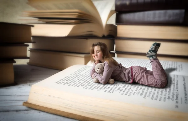 Meisje door enorme boeken — Stockfoto