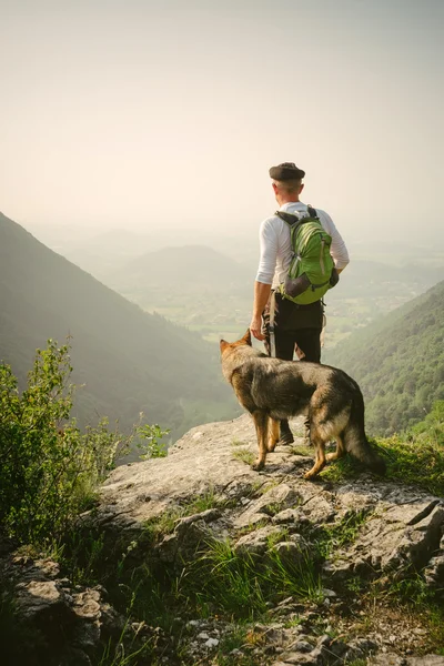 Homme et son chien dans les montagnes — Photo