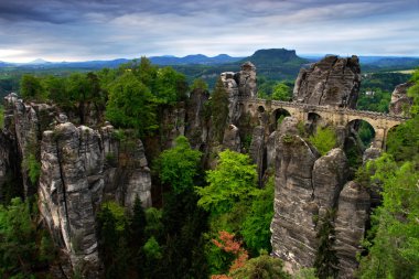 Bastei köprü gündoğumu ve sis Nehri Elbe, Sakson İsviçre Ulusal Parkı, Sakson İsviçre. Güzel Almanya manzara. Yaz sabahı Bastei anıt gri bulutlar ile. 