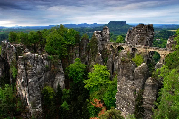 Bastei-Brücke in der Sächsischen Schweiz, bei Sonnenaufgang und Nebel über der Elbe, Nationalpark Sächsische Schweiz. schöne deutsche landschaft. Sommermorgen mit grauen Wolken im Bastei-Denkmal. — Stockfoto