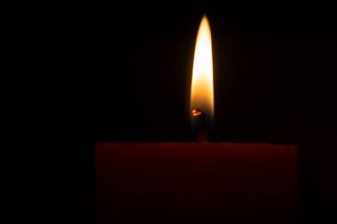 Siyah arkaplanda kırmızı yanan mum