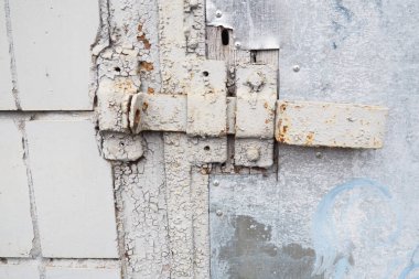 Kalın gri boyalı eski paslı kilit. Ahşap dokusu ve derisini yüzen boya.