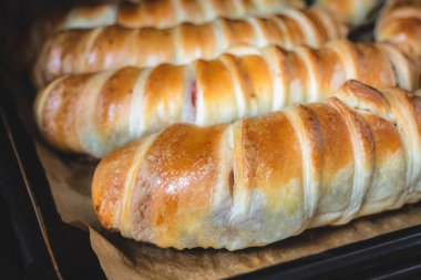 Hamurdaki sosisleri fırın tepsisine koy. Parşömen üzerinde pişirme