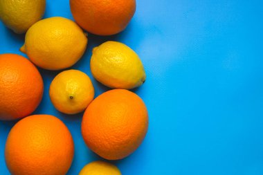 Mavi arka planda limon ve portakalların meyvelerinin karışımı. Sağlıklı beslenme, sağlıklı yemek pişirme, C vitamini ile yemek yeme kavramı..