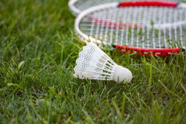 Badminton Mekik Horozu Yeşil çimlerin üzerinde direksiyon ve raket