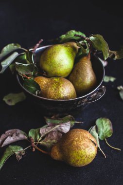 Siyah arka planda metal bir kasedeki yeşil armutların yaşam bileşimi. Estetik meyve, koyu arkaplan