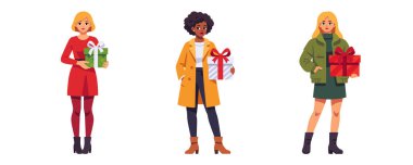 Büyük hediye kutularıyla üç kadın, şık kış kıyafetleri.