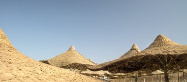 Sahilde Mısır şemsiyelerinin altında gün doğumu