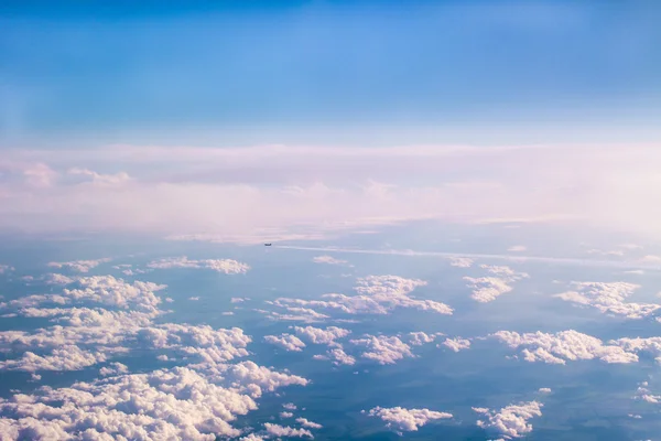 Aircraft flying away high above the clouds — Stock Photo, Image