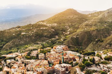 güneşli şehir dağ manzarası, mimarisi ve ağaçlar, Sicilya, İtalya