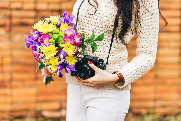 Молодая женщина держит в руках букет красивых весенних и летних цветов — стоковое фото