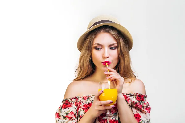 Красивая молодая женщина в шляпе с апельсиновым соком — стоковое фото