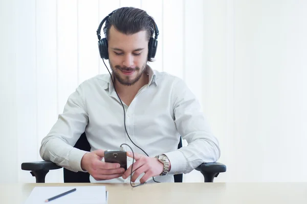 Empresário que ouve música com fones de ouvido — Fotografia de Stock