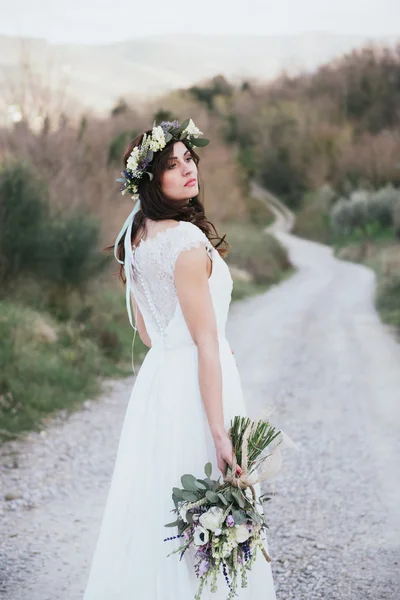 Portrait of bohemian bride in nature, with bouquet and crown of — Stock Photo, Image