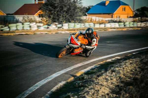 Yarış bisikleti rider parça gün hızlı bir köşeye yaslanmış.