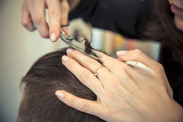 Gros plan de la main des esthéticiennes donnant une coupe de cheveux au client masculin au salon . Photo De Stock