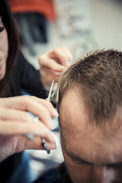 Close up van schoonheidsspecialisten hand geven een kapsel aan mannelijke klant bij Salon. Stockfoto