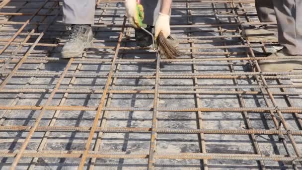 Bauarbeiter in alter Uniform gebunden Armatur auf Baustelle, Nahaufnahme. — Stockvideo