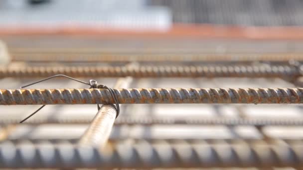 Construction worker in old uniform tied armature at construction site, close up. — Stock Video