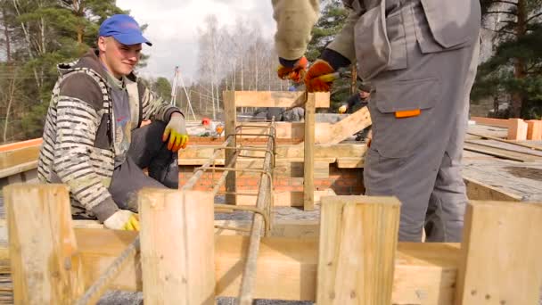 Ouvrier de la construction en vieil uniforme attaché armature sur le chantier, gros plan . — Video