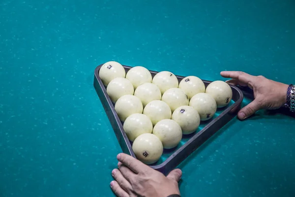 Man in voorbereiden start spel van biljartballen met driehoek Rechtenvrije Stockfoto's