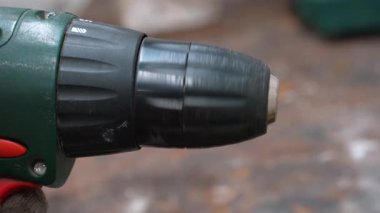 Operasyon sırasında hızla dönen bir tornavida fırlatışının aşırı yakın çekimi. İnşaat, marangozluk ve ev onarımı için kullanılan profesyonel güç aracı.