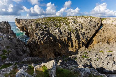 Düzensiz kıyı şekilleri, keskin uçurumlar ve Playa de Guadamia yakınlarındaki doğal hava delikleri, uçsuz bucaksız Atlantik Okyanusu. Llanes, Asturias, İspanya.