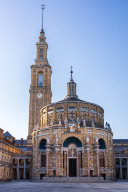 Günbatımında Laboral Kültür Şehri 'nin sakin ve boş avlusunda kilisenin devasa kubbesi ve ikonik saat kulesi yer alıyor. Gijon, Asturias, İspanya.
