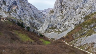 Füniküler istasyondan uzak Bulnes köyüne giden bir dağ yolu, Picos de Europa 'nın yüksek kireçtaşı zirveleriyle çevrili. Asturias, İspanya.