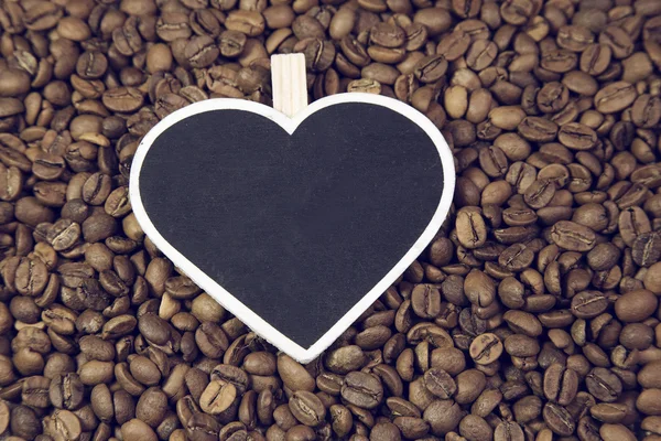 Кофейные зерна и доска для сердца — стоковое фото