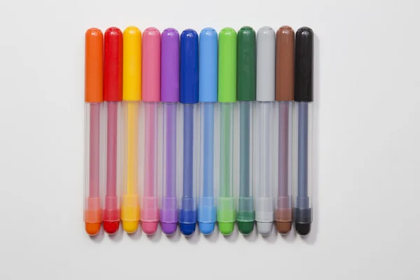 Üst üste beyaz bir arka plan üzerinde renkli kalemler