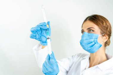 Sıvı aşılarla dolu bir şırıngayı laboratuvarda tutan doktor ya da bilim adamı olan Covid-19 Corona virüsüne karşı kavramsal mücadele: hastalıklar, tıbbi bakım, bilim.   