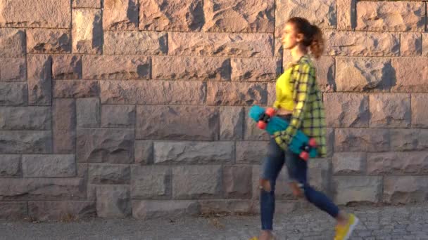 一个拿着滑板走路的年轻女人 这个年轻的女人在摆姿势玩滑板 自由和独立青年概念 — 图库视频影像