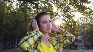 Şehirde kulaklıklı genç bir kadının düşük açılı görüntüsü. esneme.