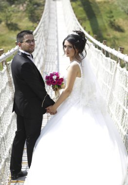 Düğün günlerinde mutlu gelin ve damat. Doğadaki düğün çifti birbirine sarılıyor. Beyaz elbiseli güzel bir kız. Takım elbiseli adam. Damat ile güzel gelin.