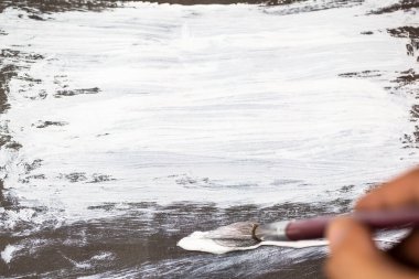 Elinde boya fırçası, siyah kağıtta beyaz boya. Soyut grunge dokusu siyah ve beyaz arkaplan