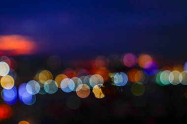 Gece şehir ışıkları arka planda ve sokak lambaları bulanık