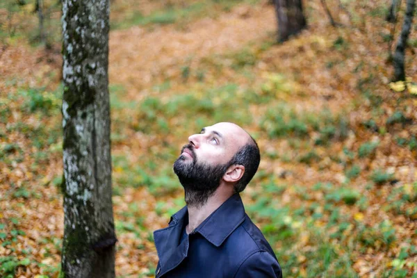 Young handsome man outdoors in fall clothing with autumn natural surroundings