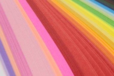 Renkli kağıt kıvrımlı şeritler parlak bir zemin oluşturuyor. Titrek gökkuşağı renkleri, yakın plan. Arkaplan için renkli soyut çizgiler.