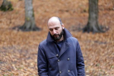 Sonbahar doğal ortamında sonbahar kıyafetleri içinde genç ve yakışıklı bir adam.