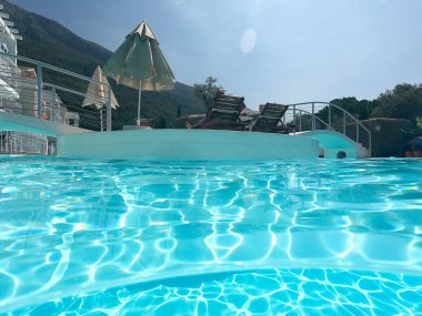 Mavi yüzme havuzunun yüzeyi, yüzme havuzundaki suyun arka planı.