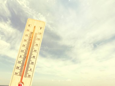 Çok sıcak bir günde termometre, yüksek sıcaklık veya sıcak çevre konsepti. Gökyüzündeki termometre, sıcaklık